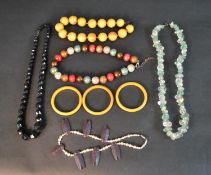 A collection of costume jewellery including three Bakelite bangles, a large striped Bakelite bead