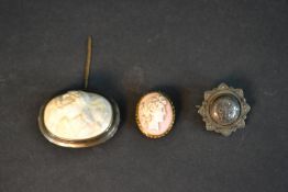 Two Victorian carved shell cameo brooches and a silver mourning brooch. The large oval shell cameo