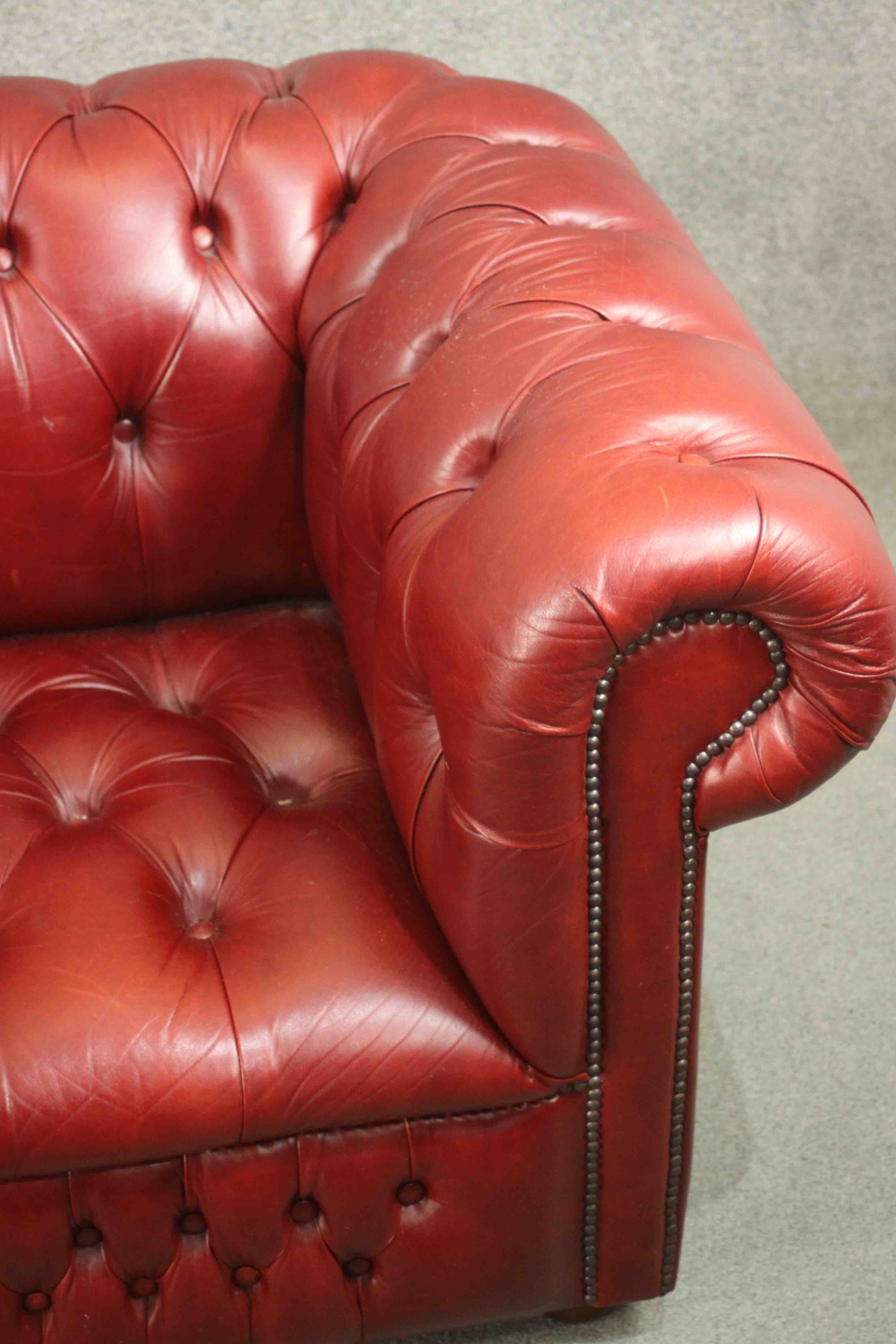 A red leather Chesterfield sofa, buttoned to the back, arms, seat, and front, on bun feet. H.75 W. - Image 6 of 8