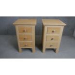 A pair of contemporary oak bedside chests each with three drawers and painted floral handles. H.73