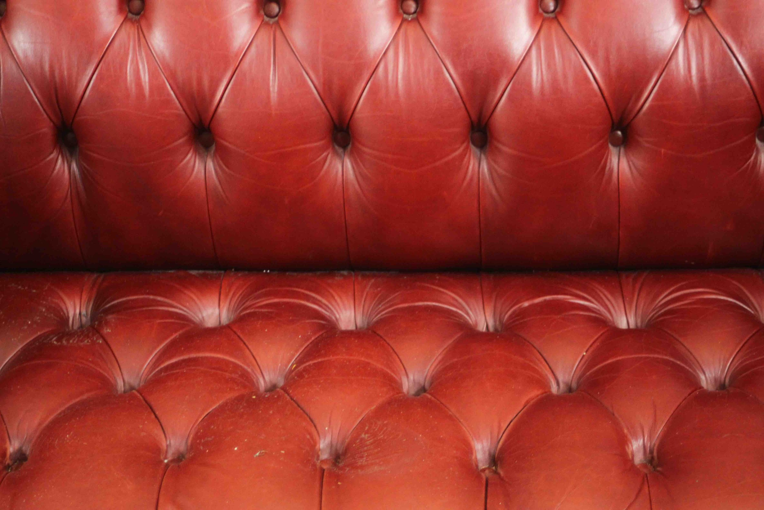 A red leather Chesterfield sofa, buttoned to the back, arms, seat, and front, on bun feet. H.75 W. - Image 4 of 8