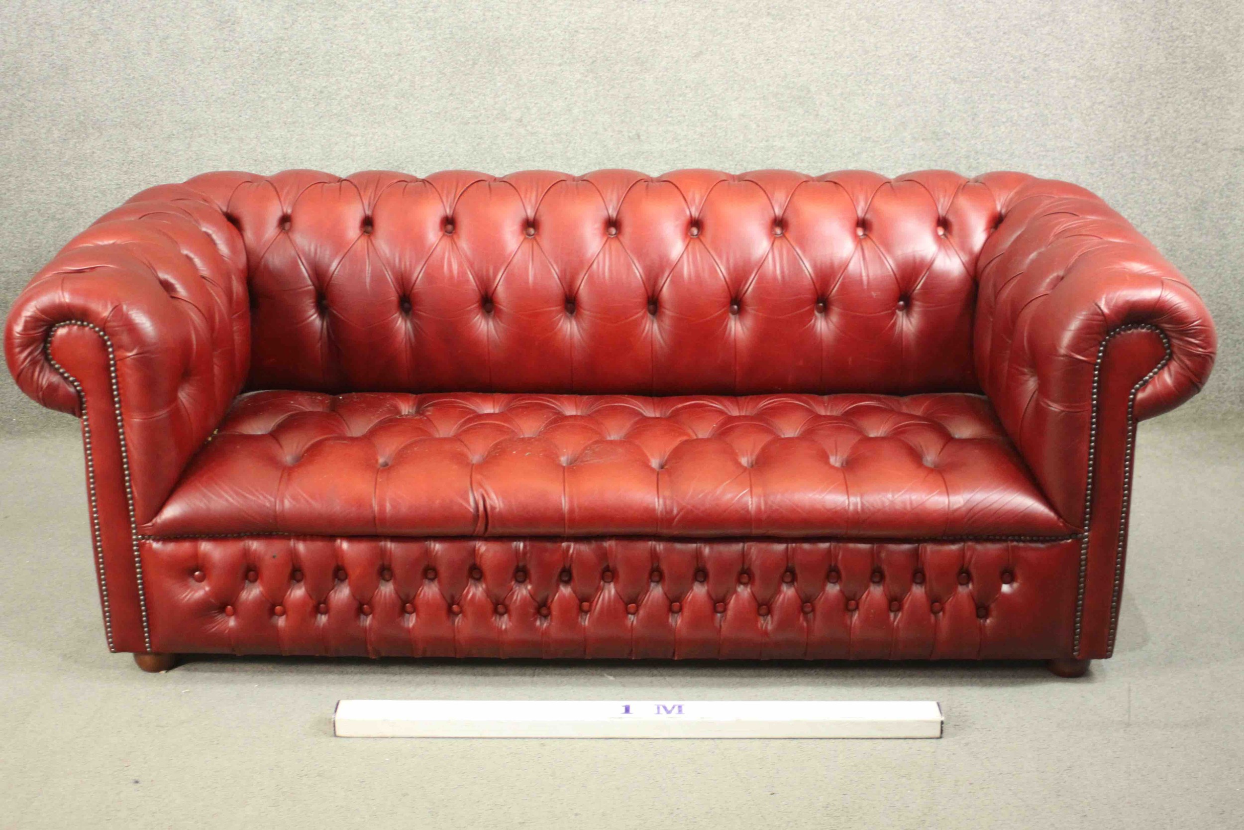 A red leather Chesterfield sofa, buttoned to the back, arms, seat, and front, on bun feet. H.75 W. - Image 3 of 8