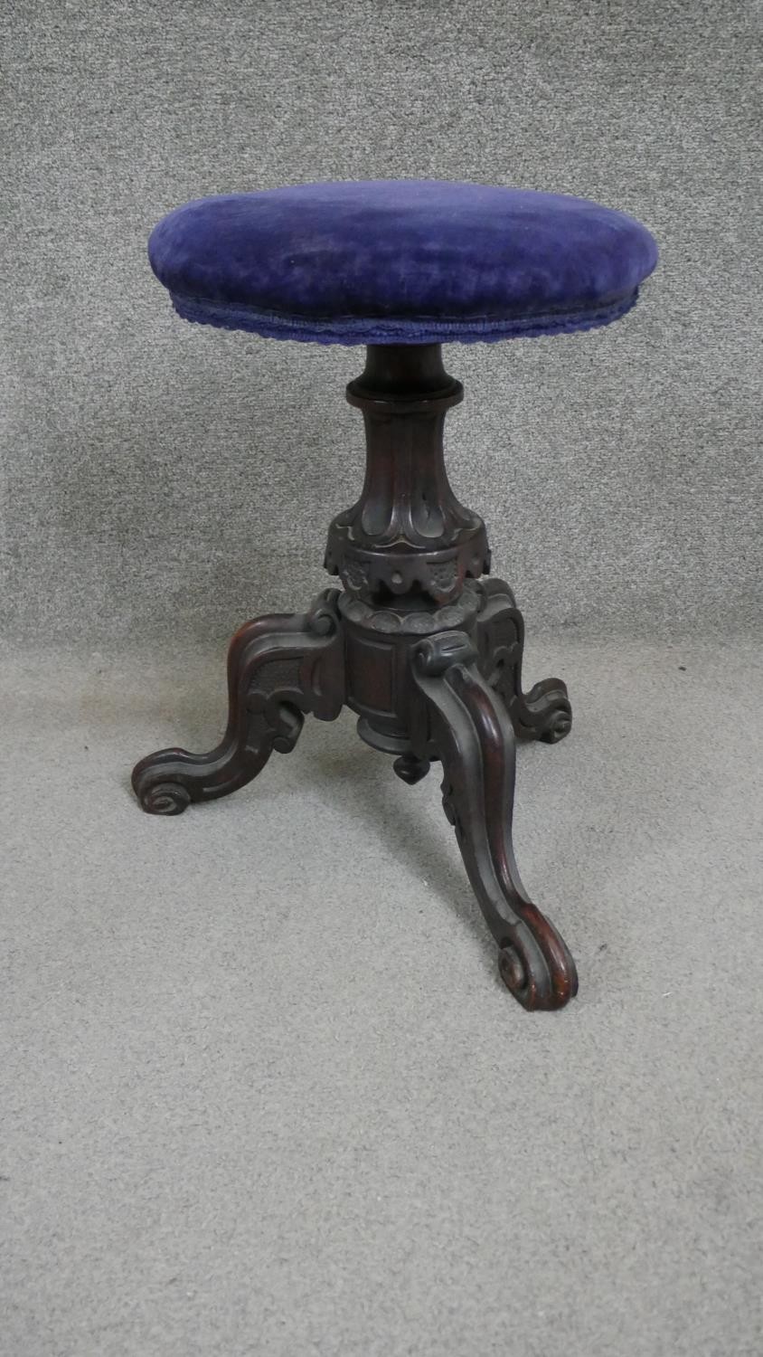 A Victorian mahogany stool, the circular seat upholstered in blue velour on a carved baluster stem