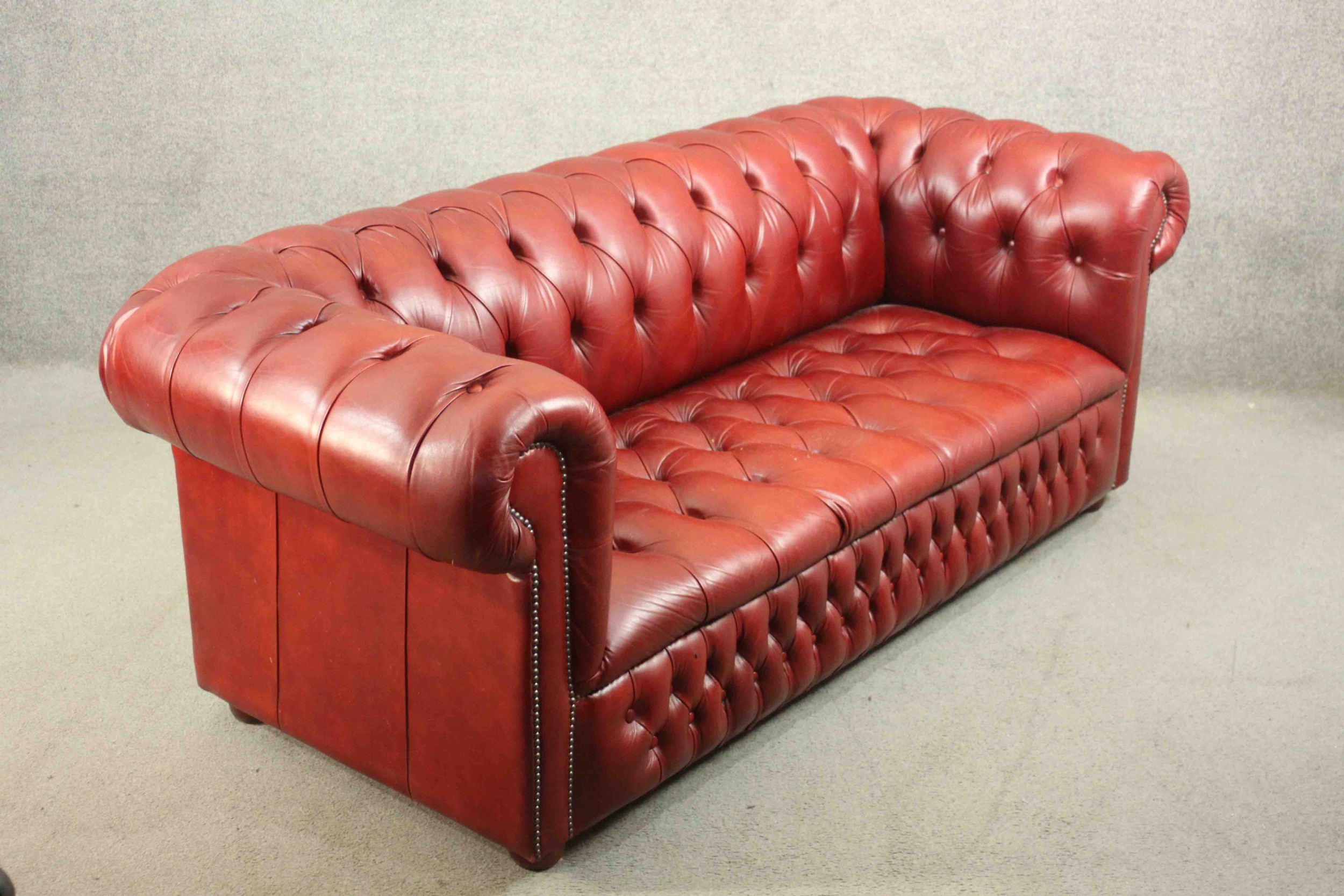 A red leather Chesterfield sofa, buttoned to the back, arms, seat, and front, on bun feet. H.75 W. - Image 2 of 8