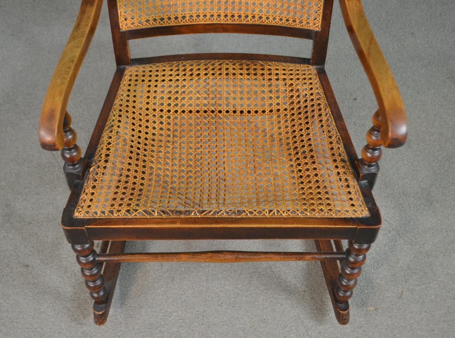 A circa 1900 stained beech rocking chair, with a caned back and seat, open arms, with bobbin - Image 3 of 5