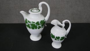 A circa 1970s Meissen porcelain coffee pot and milk jug, decorated with a green vine pattern, the