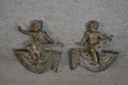 A pair of 19th century bronze finials in the form of putti musicians on swags. H.32 W.27cm