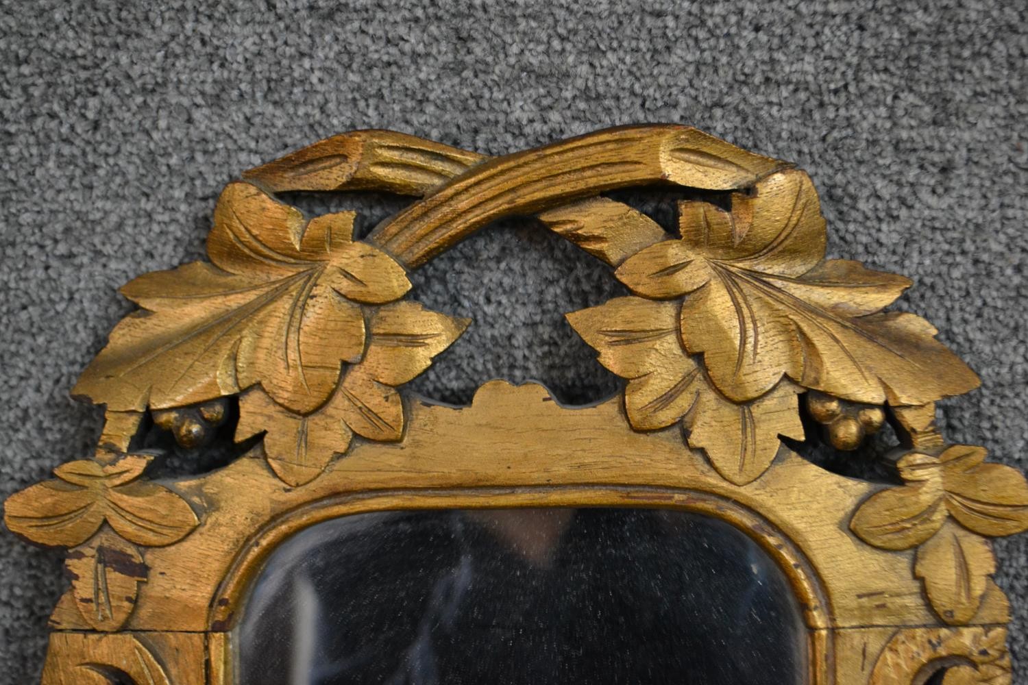 A carved giltwood mirror, the rectangular mirror plate with rounded corners in an ornately carved - Image 4 of 4