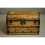 A Victorian pine trunk, of rectangular form with a domed lid, iron mounted and timber bound, the