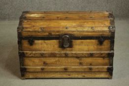 A Victorian pine trunk, of rectangular form with a domed lid, iron mounted and timber bound, the