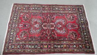 A red ground handmade Persian Hamadan rug with a central medallion L.157 W.106cm