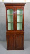 A late Victorian walnut bookcase, of narrow proportions with two glazed doors, enclosing a mint