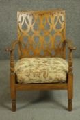 A circa 1920's beech open armchair with an ornate pierced back over curved arms, above an