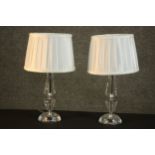 A pair of contemporary cut glass table lamps, with white pleated shades. H.40 Dia.19cm.