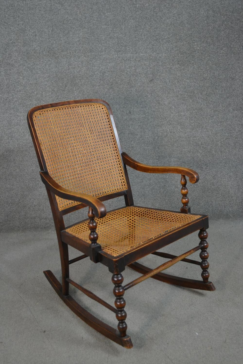 A circa 1900 stained beech rocking chair, with a caned back and seat, open arms, with bobbin - Image 2 of 5