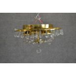 A contemporary circular tiered brass ceiling light, hung with faceted glass lustres. Diam.32cm