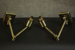 A pair of contemporary brass wall lights, each with an adjustable arm on a rectangular back plate.