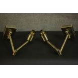 A pair of contemporary brass wall lights, each with an adjustable arm on a rectangular back plate.