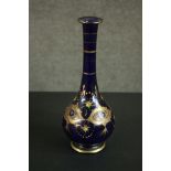 An early 20th century Bohemian blue glass vase with gilded and enamel painted floral design. H.33