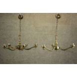 A graduated pair of contemporary brass chandeliers, one with five scrolling arms, the other with