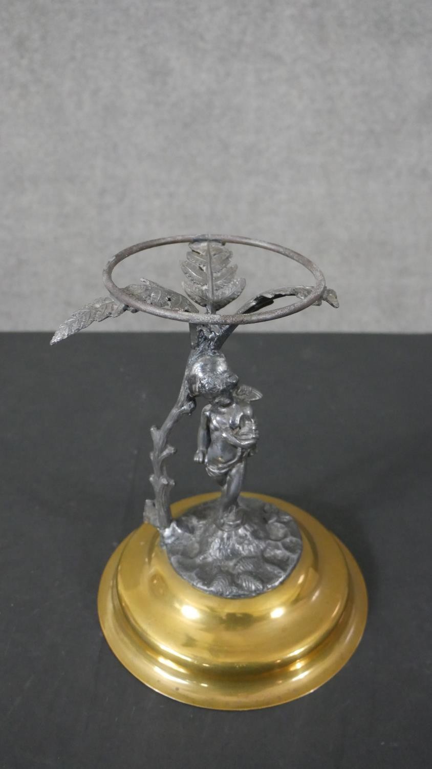 A Victorian Australian design brass an silver plated stand modelled in the figure of a cherub with a
