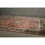 A fine handmade red ground Persian Keshan carpet with central medallion. L.320 W.200cm.