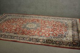 A fine handmade red ground Persian Keshan carpet with central medallion. L.320 W.200cm.