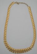 A red leather boxed 9ct yellow gold West German textured articulated link necklace with graduated