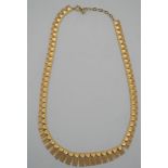 A red leather boxed 9ct yellow gold West German textured articulated link necklace with graduated