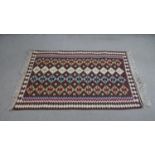 A handmade maroon ground Kelim rug with geometric design. L.147 D.101cm