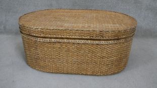 A wicker box of oval form. H.95 W.112 D.73cm