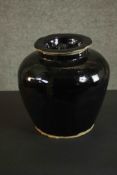 A large provincial Chinese black ware ceramic storage jar with lid. H.25cm.