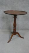 A 19th century walnut tripod occasional table with a circular top on a turned baluster stem and