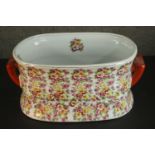 A Victoria Ware ironstone footbath, transfer printed with polychrome flowers, with twin handles. H.