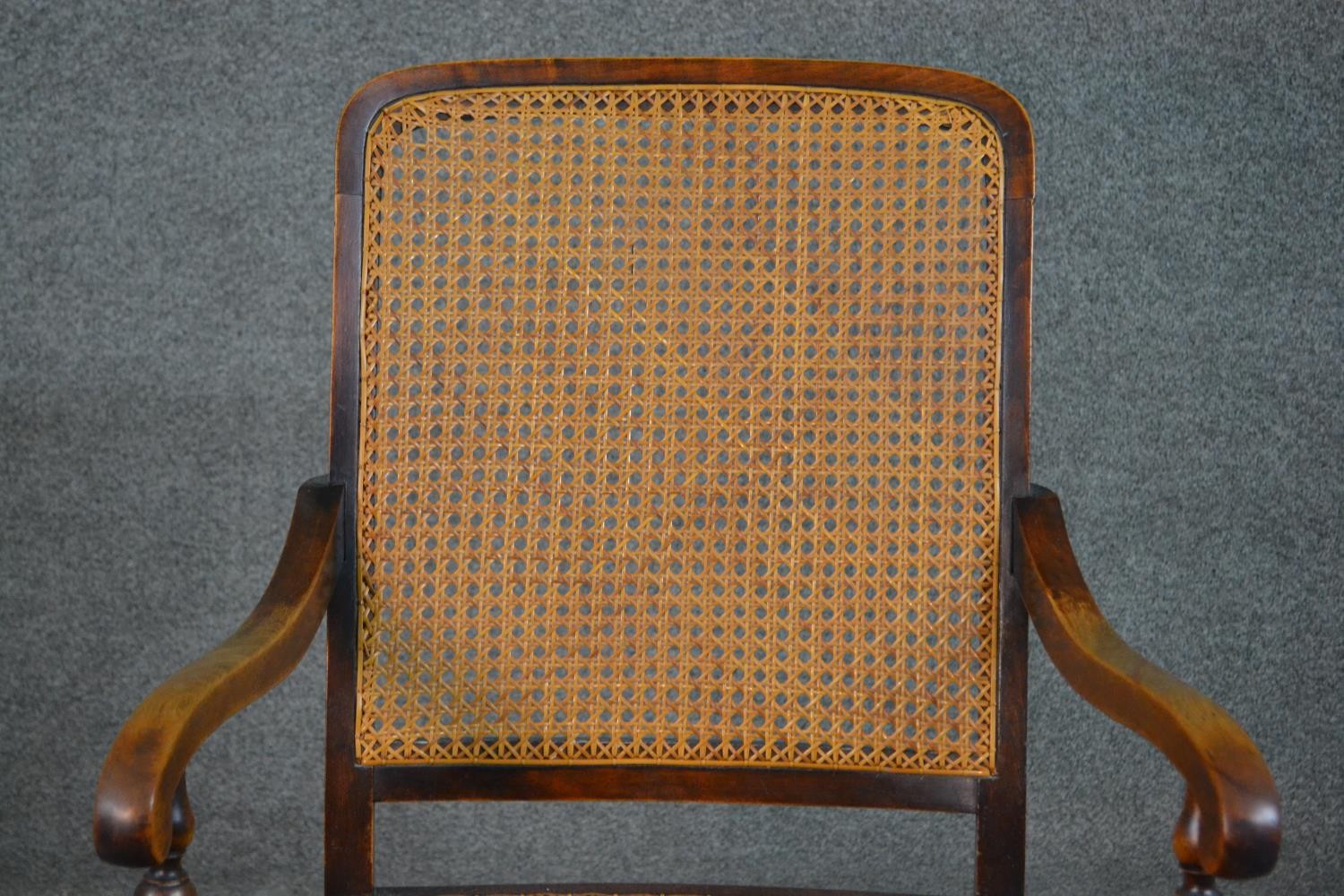 A circa 1900 stained beech rocking chair, with a caned back and seat, open arms, with bobbin - Image 4 of 5