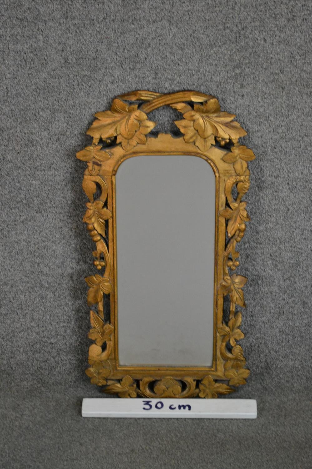 A carved giltwood mirror, the rectangular mirror plate with rounded corners in an ornately carved - Image 2 of 4
