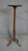 A 20th century fruitwood torchère in George III style with a circular top on a turned and reeded