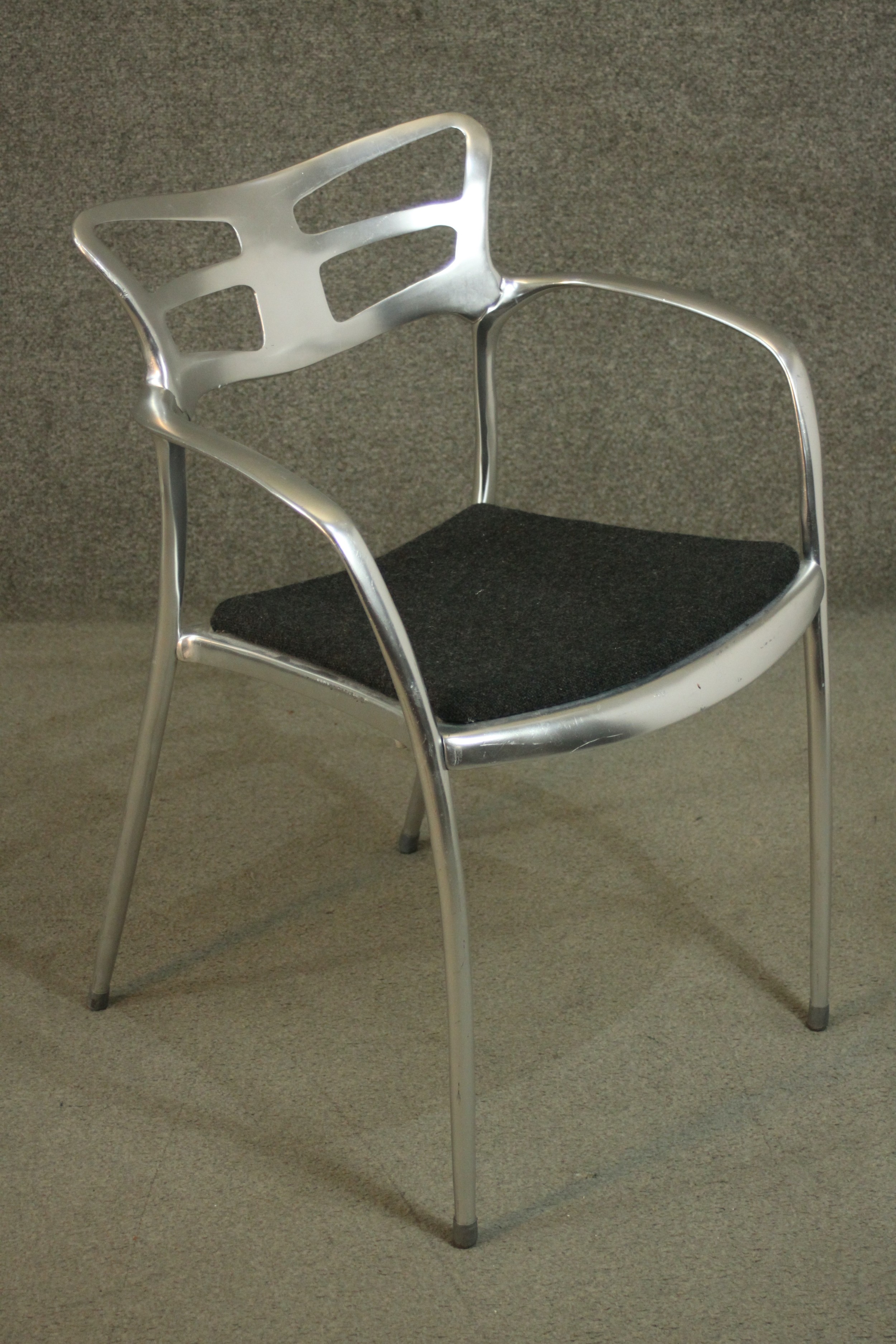 A Liceo chair by Alutec, made from cast aluminum, with open arms, and a dark grey upholstered