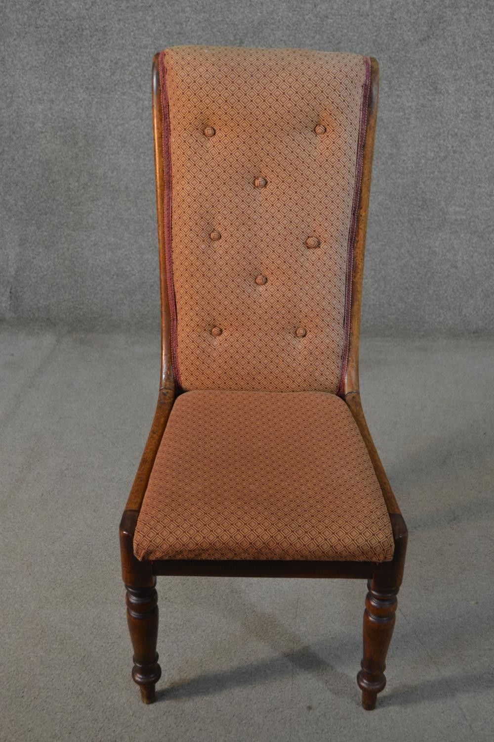 A George III mahogany side chair, with a buttoned back, upholstered in brown fabric, on turned legs.