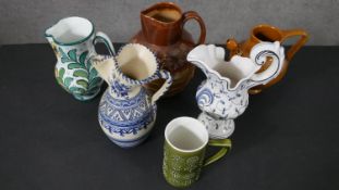 Six art pottery and ceramic jugs, including a Doulton style Tobacco jug with hunting scene. Some