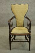 A circa 1900 open armchair, with a shaped back, and spindles to the curved arms, with yellow