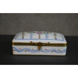 A Limoges porcelain hand painted trinket box with flower garlands and scrolling motifs. Inscribed