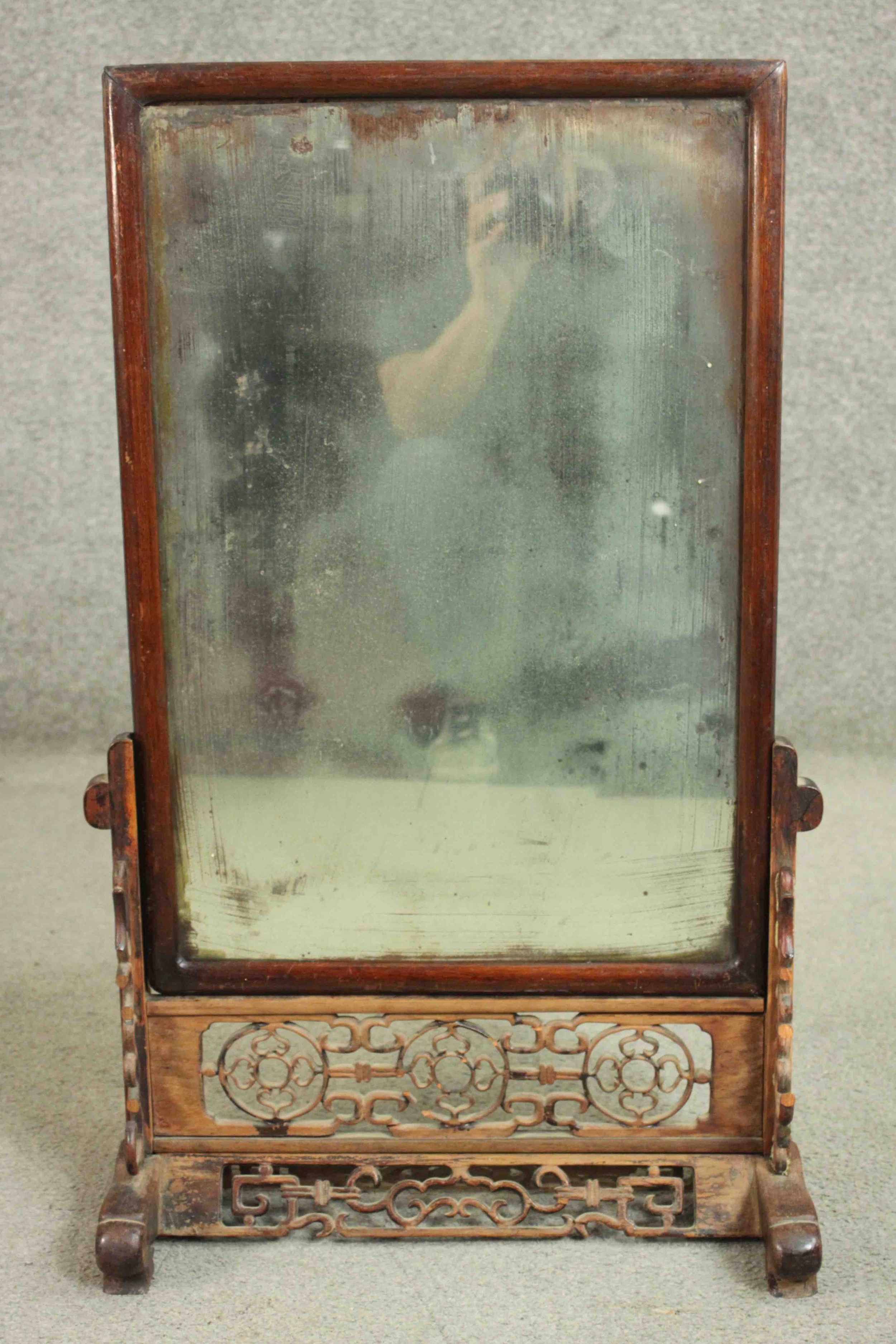 A 19th century Chinese dressing mirror on carved and pierced stand. H.82 W.53. D.23cm.