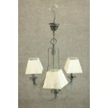 A late 20th century wrought verdigris metal three branch chandelier, with ivory coloured pleated