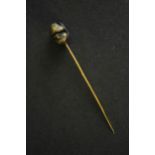 A Japanese Meji period Shakudo ware stick pin one side with a man's face and the other side with a