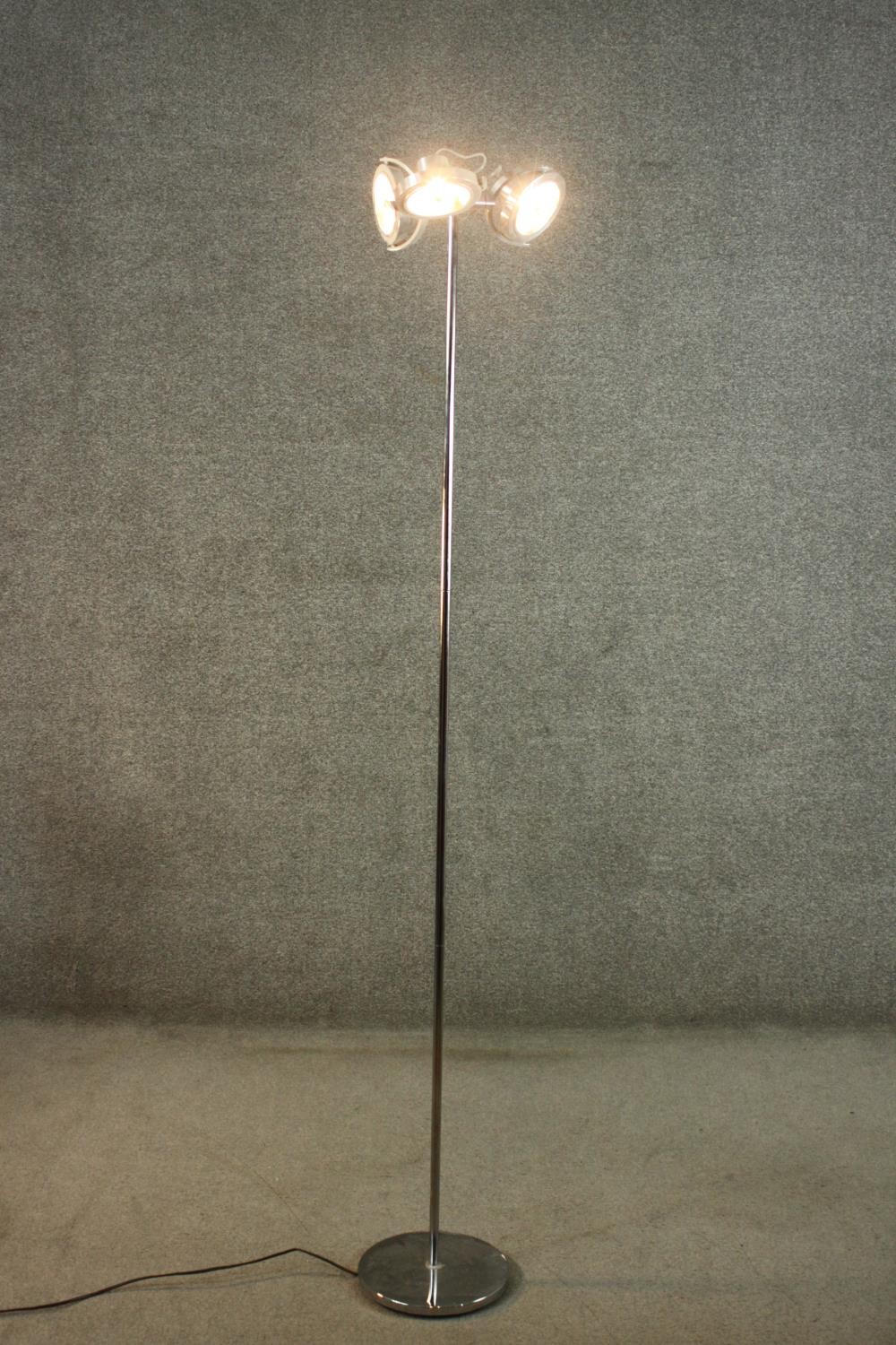 A modernist tubular chromed standard lamp, with three adjustable spotlights, on a circular base. H.