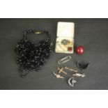 A collection of jewellery and other curiosities, including a cherry amber bead, a novelty cigar