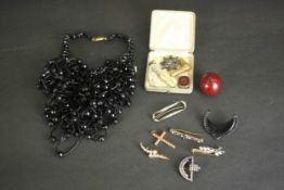 A collection of jewellery and other curiosities, including a cherry amber bead, a novelty cigar