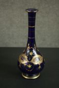 An early 20th century Bohemian blue glass vase with gilded and enamel painted floral design. H.33