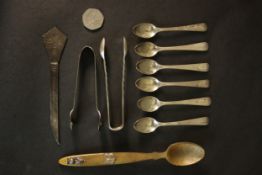 A collection of silver and white metal spoons and sugar tongs, including a Scottish horn and